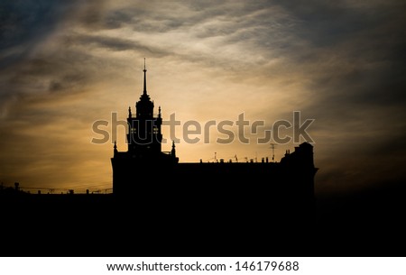 Silhouette of an old building on a background of a sunset