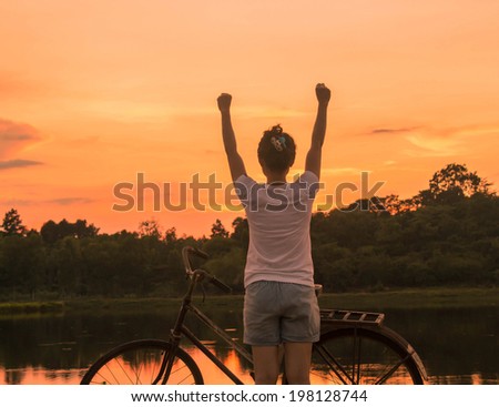 Happy celebrating winning success woman at sunset.