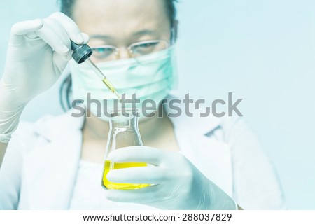 Medical or scientific researcher with flask making test or research in clinical laboratory.
