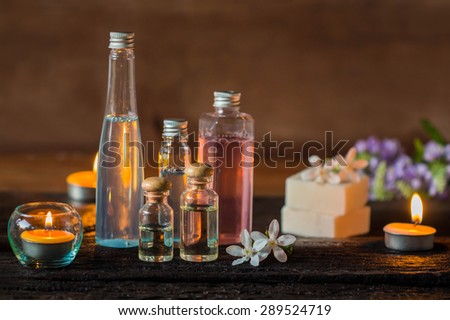Spa treatment with scented candles and soap on wood.