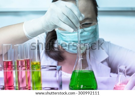 Medical or scientific researcher with flask making test or research in clinical laboratory