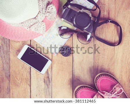 Preparation for travel,trip vacation, tourism mock up of cell phone,road map,compass,camera,hat,shoes on wooden table.