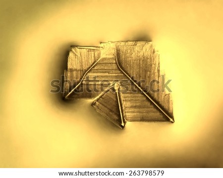 Photographic image of a microscopic table salt crystal illuminated by incandescent light and magnified 25x