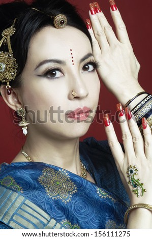 Beautiful asian woman in traditional clothing with bridal makeup and jewelry-red background