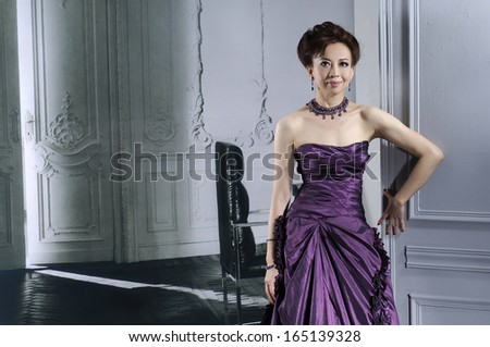 half length portrait of beautiful young woman wearing purple luxurious dress