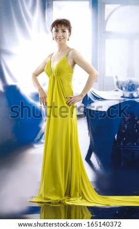full-length beautiful woman wearing yellow wedding dress posing