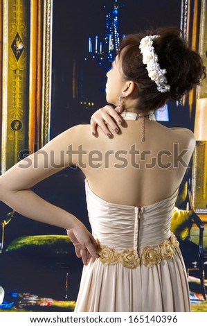 Portrait of Beautiful Woman posing in a wedding dress back