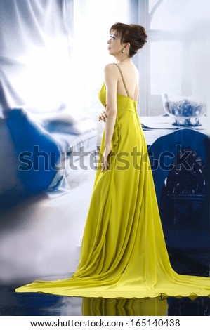 full-length side view beautiful woman wearing yellow wedding dress back posing