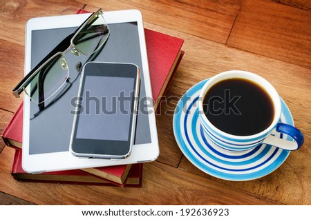 empty tablet pc and a coffee and Mobile phone with book on the office desk