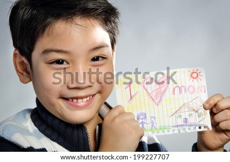 Little asian boy  holding picture wiith word \