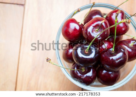 Fresh red Cherries on wooden table with water drops macro background