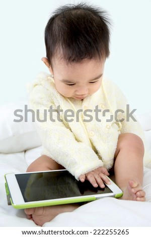 Asian baby happy play game touching with tablet PC