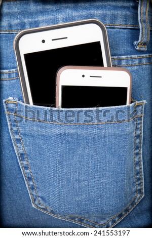 Big and small Smart phone in back pocket of girl\'s jeans .