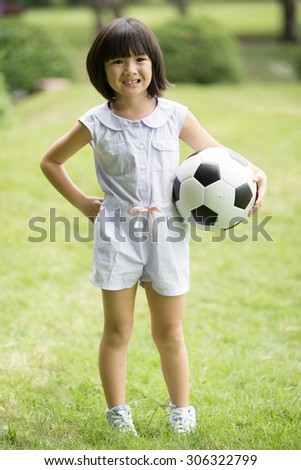 Little asian girl playing football at the park,Bangkok Thailand