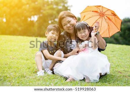 Happy Asian Family Enjoying Day In Park with sun light effect .