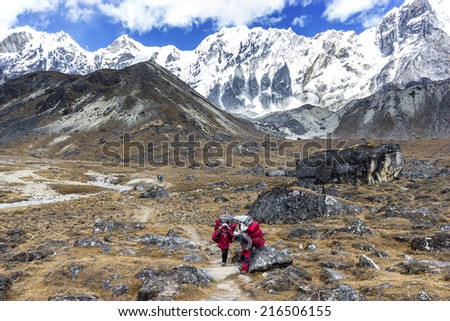 CHO LA PASS, NEPAL - OCTOBER 18, 2011: Porters with heavy load after crossing Cho La Pass in Himalayas, located 5,420 meters (17,782 ft) above sea level in Solukhumbu District in northeastern Nepal.