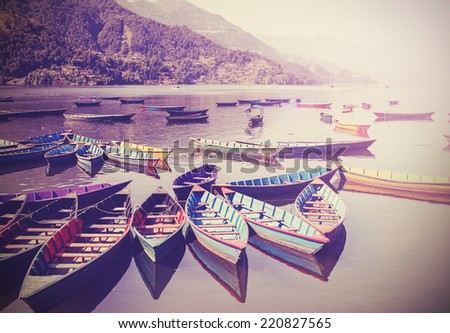 Vintage picture of small boats on lake with retro filter.