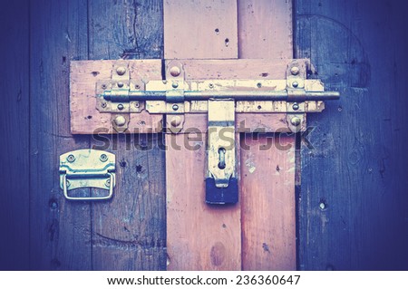 Retro vintage style picture of wooden door with lock.