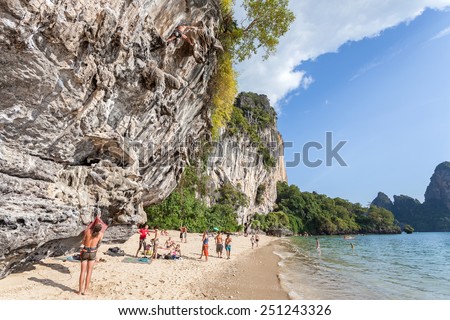 RAILAY, THAILAND - DECEMBER 31, 2014: Rock climbers and tourists on Railay beach, one of the most popular rock climbing locations in Asia.