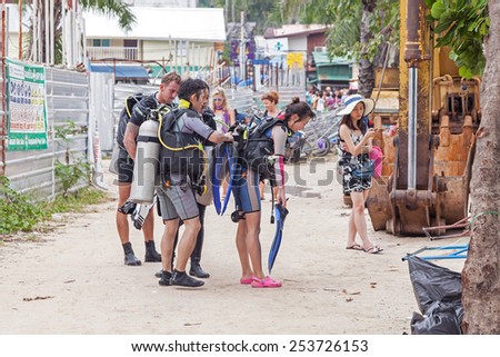 PHI PHI ISLAND, THAILAND - JANUARY 6, 2015: Divers walking back from diving trip. Phi Phi is one of the most popular islands and diving spots in Thailand.
