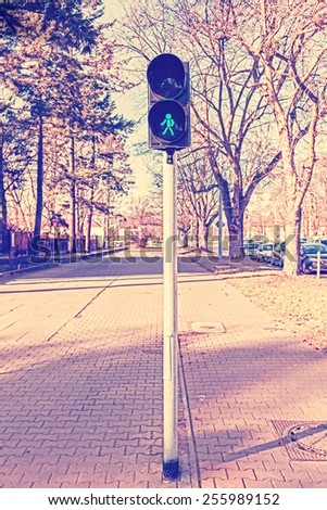 Retro filtered photo of traffic lights, green color.