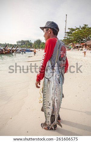 KOH LIPE, THAILAND - JANUARY 11, 2015: Local fisherman with two big fishes on the beach.