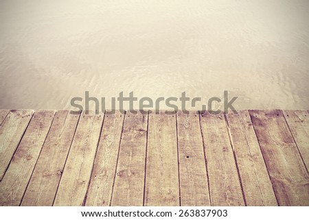 Retro stylized picture of wooden boards and lake, background with space for text.