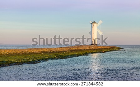 Sunrise over Baltic Sea coast, lighthouse in Swinoujscie, Poland.