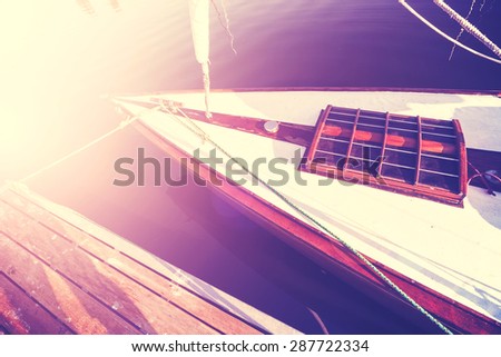 Vintage instagram style photo of a sailing boat at sunset.