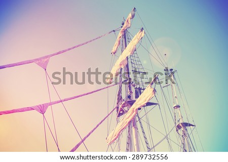 Vintage retro instagram style picture of a sailing ship mast with lens flare effect.