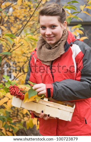 Portrait of teenage girl with basket of autumn leaves and berries