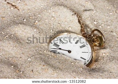 Antique golden watch lost in the sand