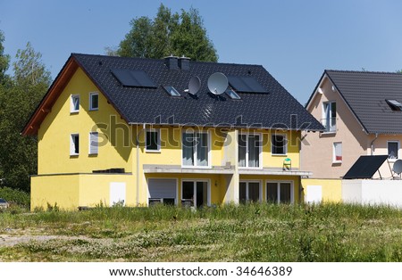 Houses with solar panels and satellite dishes under construction
