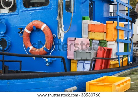 Fish cutter with colorful shipping containers and life belt