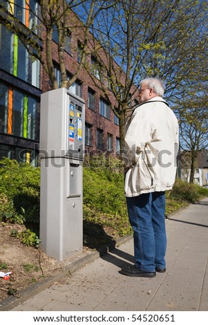 Elderly Man Standing beside Parking Ticket Machine