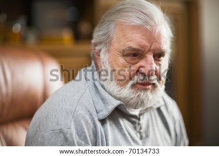Older man with black eye, beard and white hair, serious expression