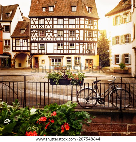 Bicycle on cobblestone street with half timbered houses in Colmar old city, Alsace, France. Toned in warm colors.