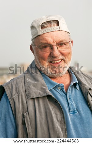 Portrait of smiling happy senior man outdoors looking at the camera