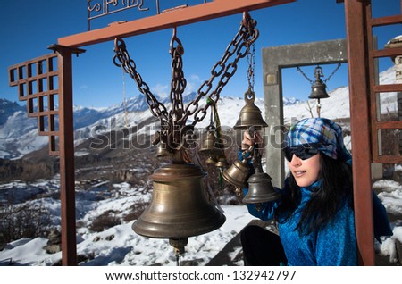 Girl of the bells in the high snowy mountains of the Himalayas