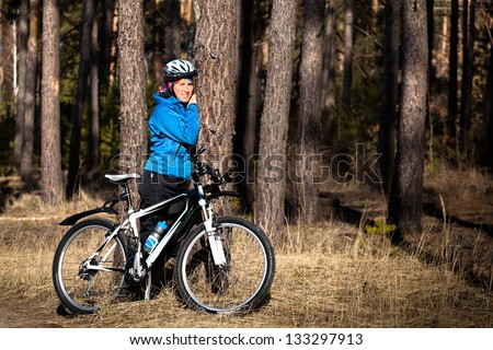 Girl with bike resting in a pine forest