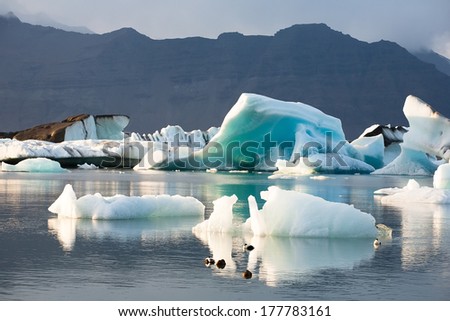 Stunning Atmosphere Of Huge Iceberg Reflecting In The Cool Glacial Water.
