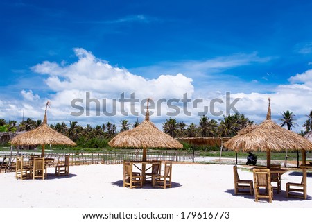 Outdoor restaurant at the beach. Cafe on the beach, ocean and sky. Table setting at tropical beach restaurant. lounge chairs for relaxing and sunbathing