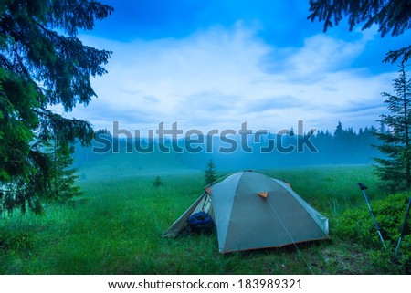 landscape of fog in the field at sunrise in the forest summer, lonely tent