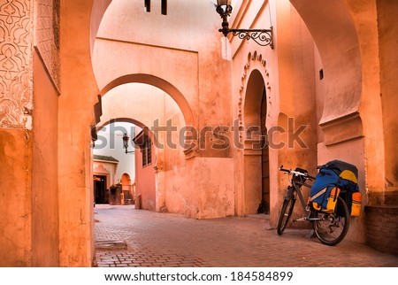 mountain bike standing near a red wall in the Muslim city of Marrakech in the street with beautiful arches and walls, ornamented tiles.