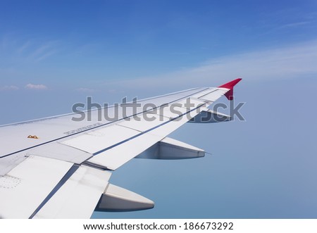 Wing of the plane on sky background - view from the window of a plane of the wing, the sky - View of jet plane wing