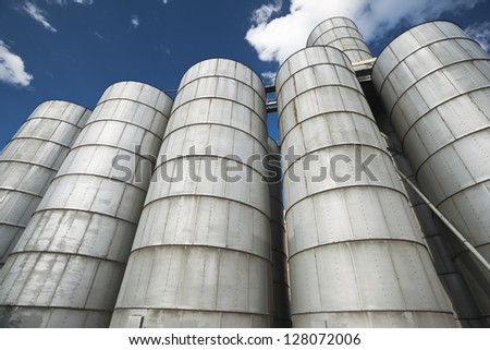Cereal silos under the blue sky.A row of grain silos set in an agricultural processing plant