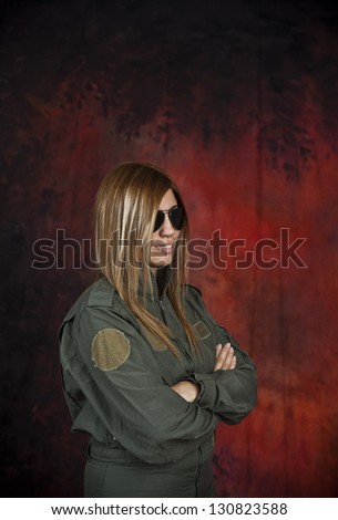 Beautifull woman pilot with sun glasses in front of red and black background