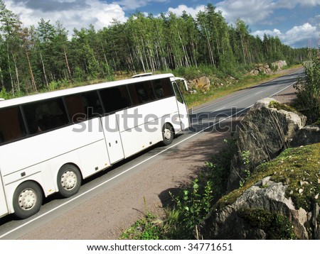 white tourist bus on rural highway, slightly blurred in motion