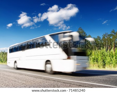 white tourist bus speeding on highway, blured in motion