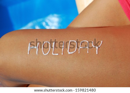 Female legs with the inscription holiday from sunscreen.